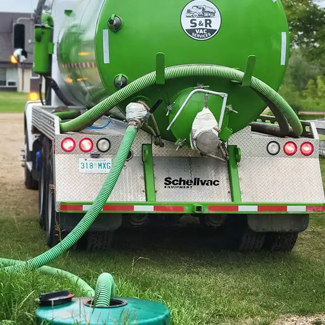 Septic Vac Truck With Hose Running Into Septic Tank